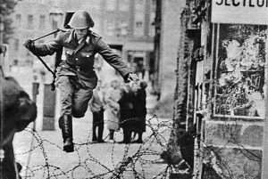 An East German soldier leaps over the barricade to escape East Berlin in August 1961, just as the Berlin Wall is being built